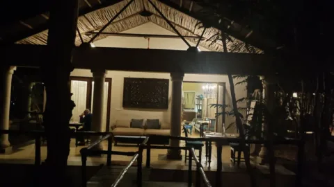 Lantern-lit jungle dining pavilion at night, Pench