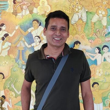 Sam V Aiyar of CookingTantra in front of a Kerala mural
